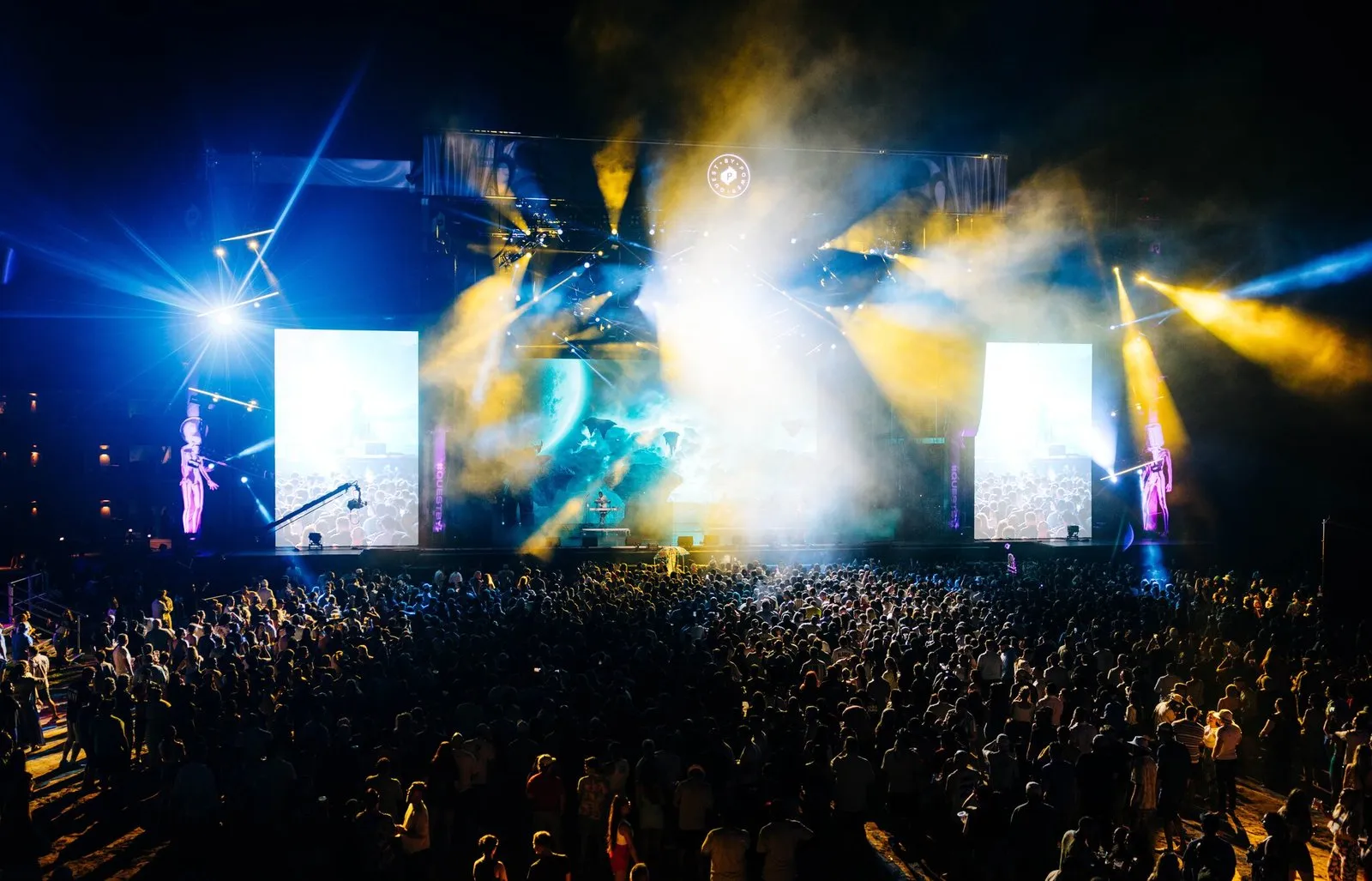 The main stage at night, a vertical side screen either side of the band