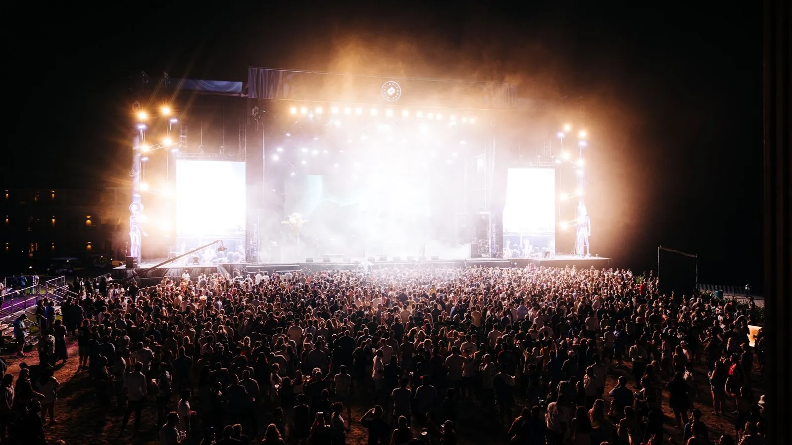 The main stage from the back of the crowd, both side screens lit