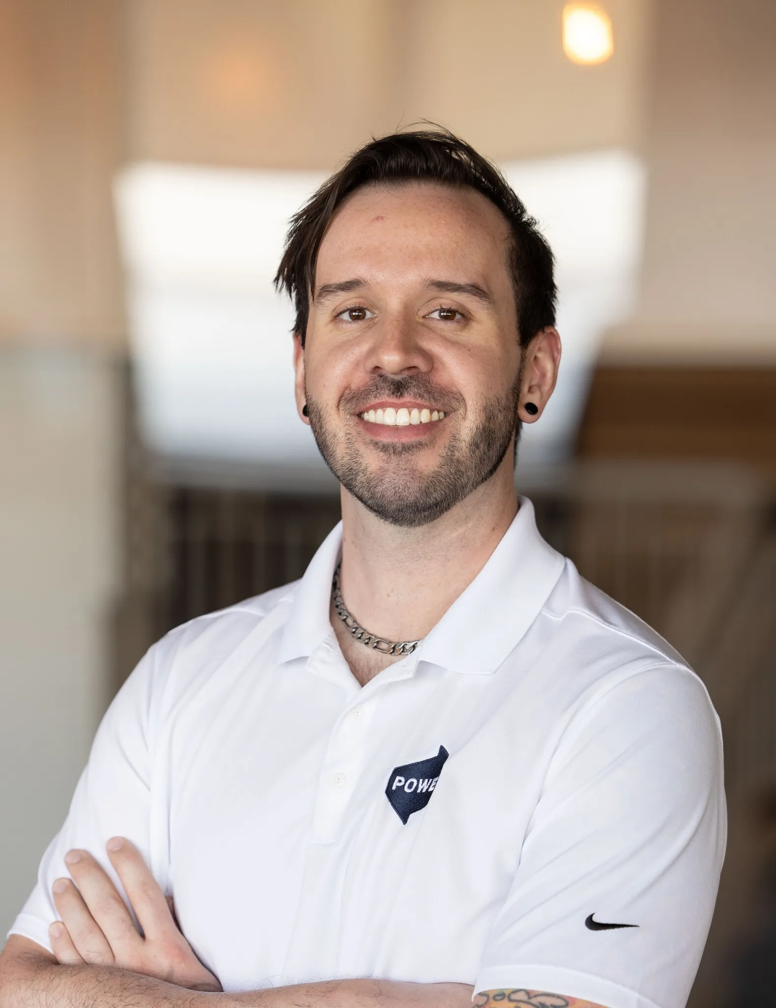 Matt Rodenbeck, smiling, in a white polo, arms crossed