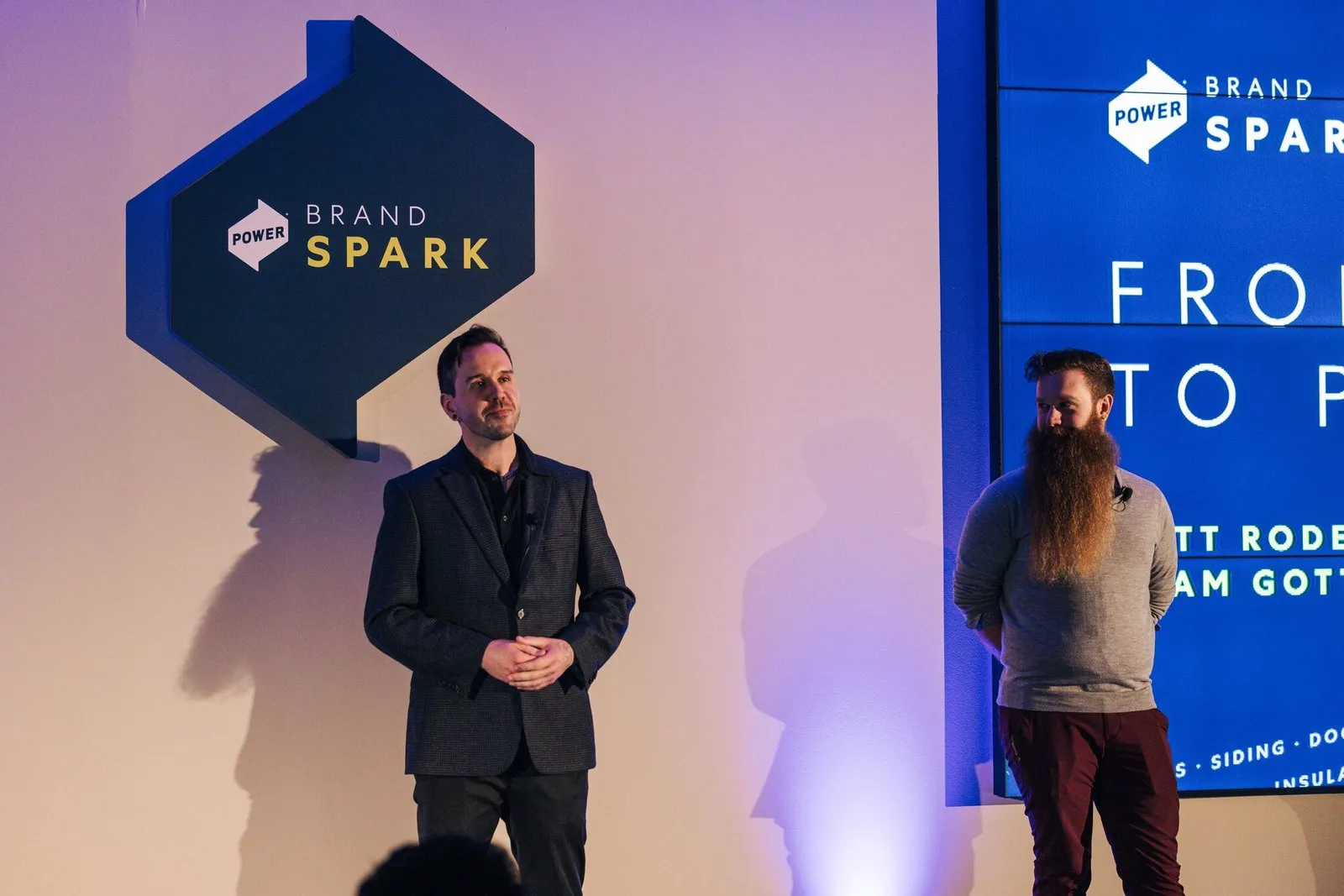 Matt and Adam on stage at Brand Spark 2024, the title slide behind them